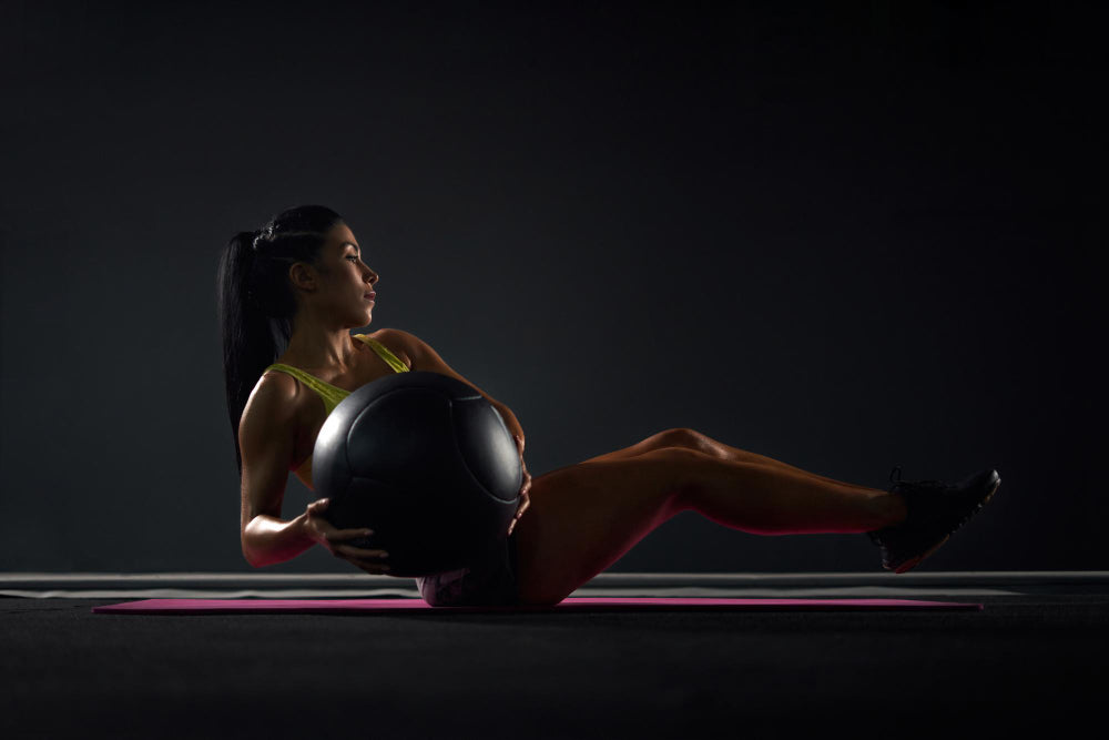 woman-working-out-with-medicine-ball-and-yellow-top